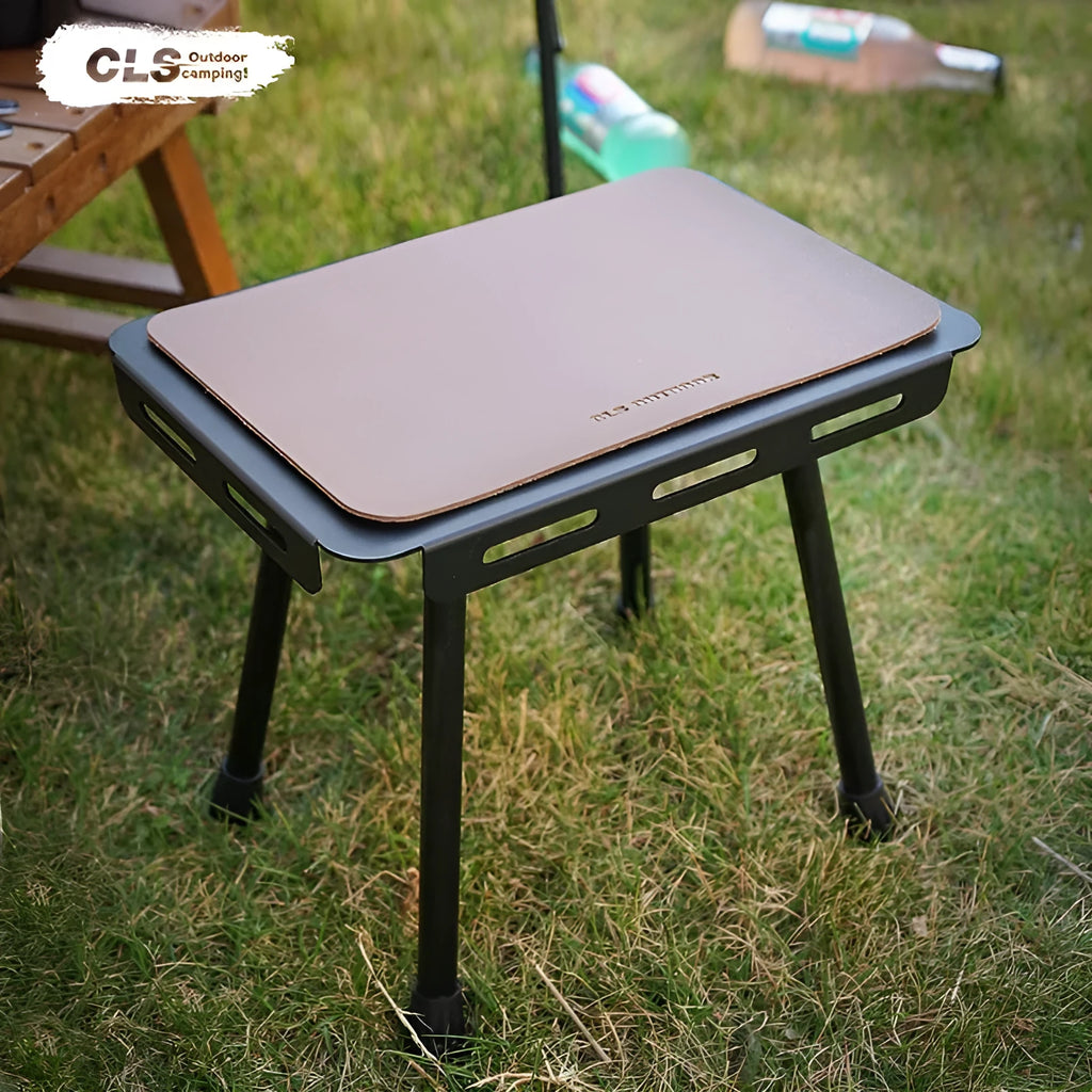 Aluminium folding camping stool that converts into a small table, shown with a tactical storage bag and a beige PU cushion.