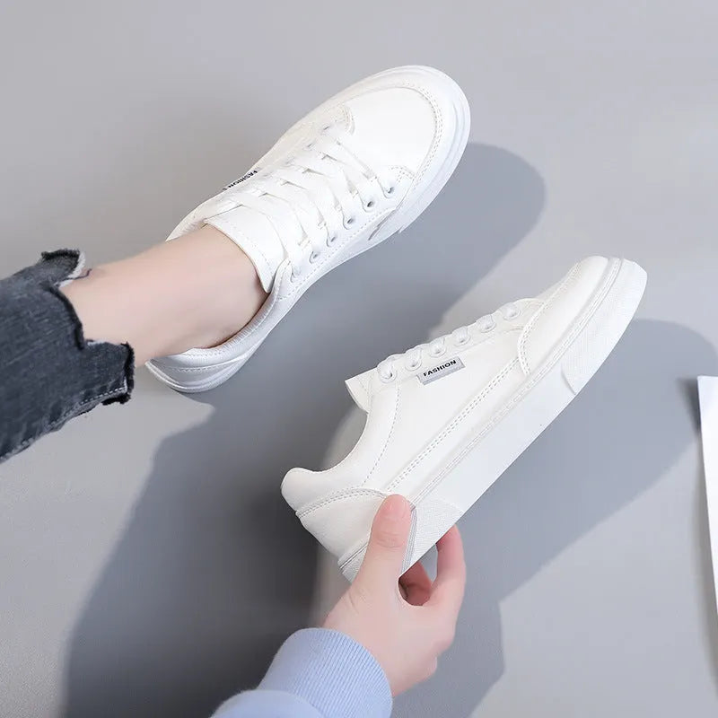 Women's brown and white Korean-style low-top sneakers with artificial PU uppers on solid background.