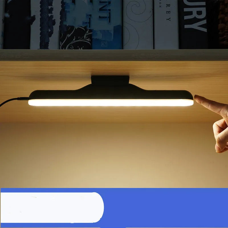 Modern minimalist white plastic LED desk lamp with a touch-sensitive base on a wooden desk.