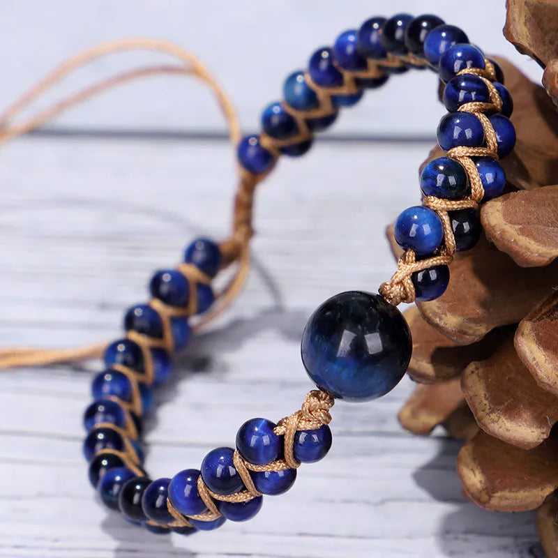 Handmade woven geometric bracelet with blue tigereye stone beads and adjustable pull closure.