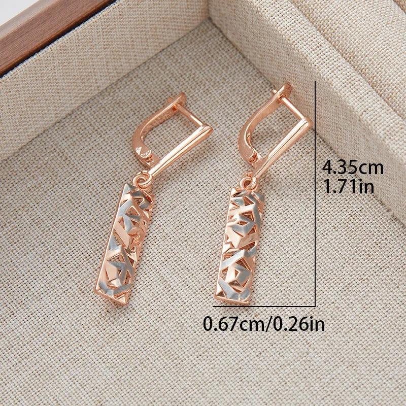 A pair of rectangular hollow stud earrings with a two-tone geometric design on a white background.