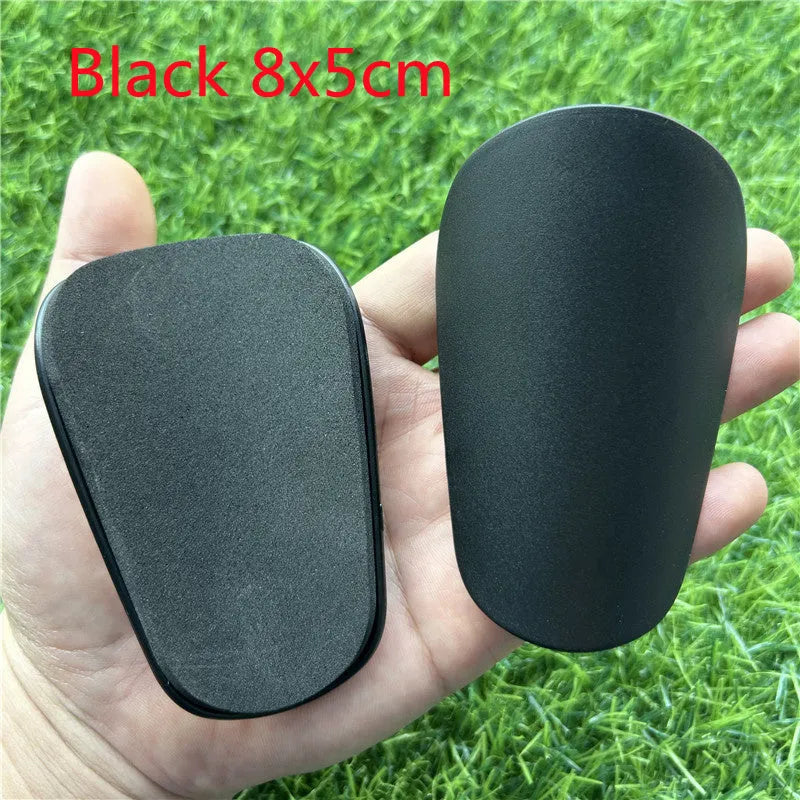 Extra small 8x5cm plastic football shin guards in black and white colours