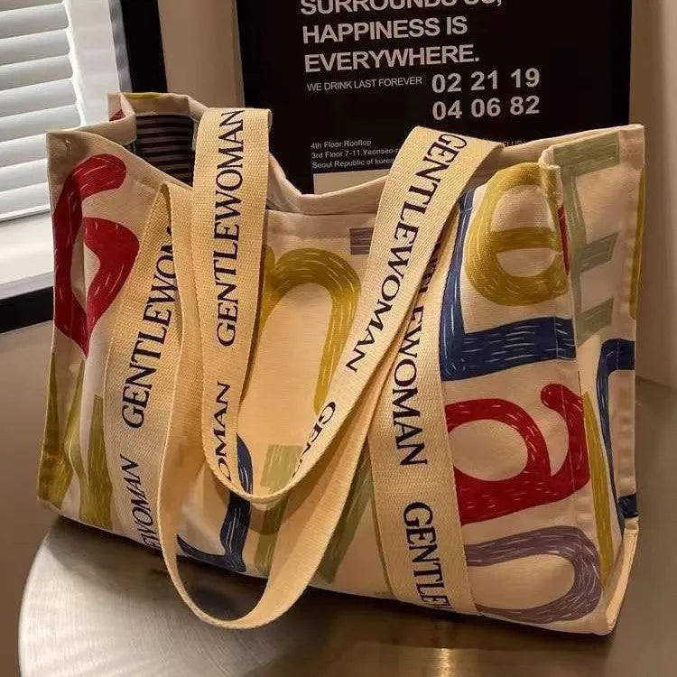 Large canvas women's travel tote bag with print design options including black letters and patterns.