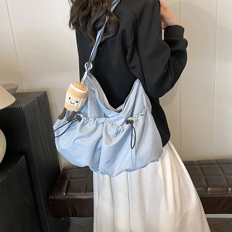 Ultra-light pleated foldable crossbody bag in soft polyester fabric, shown in green with split pockets.