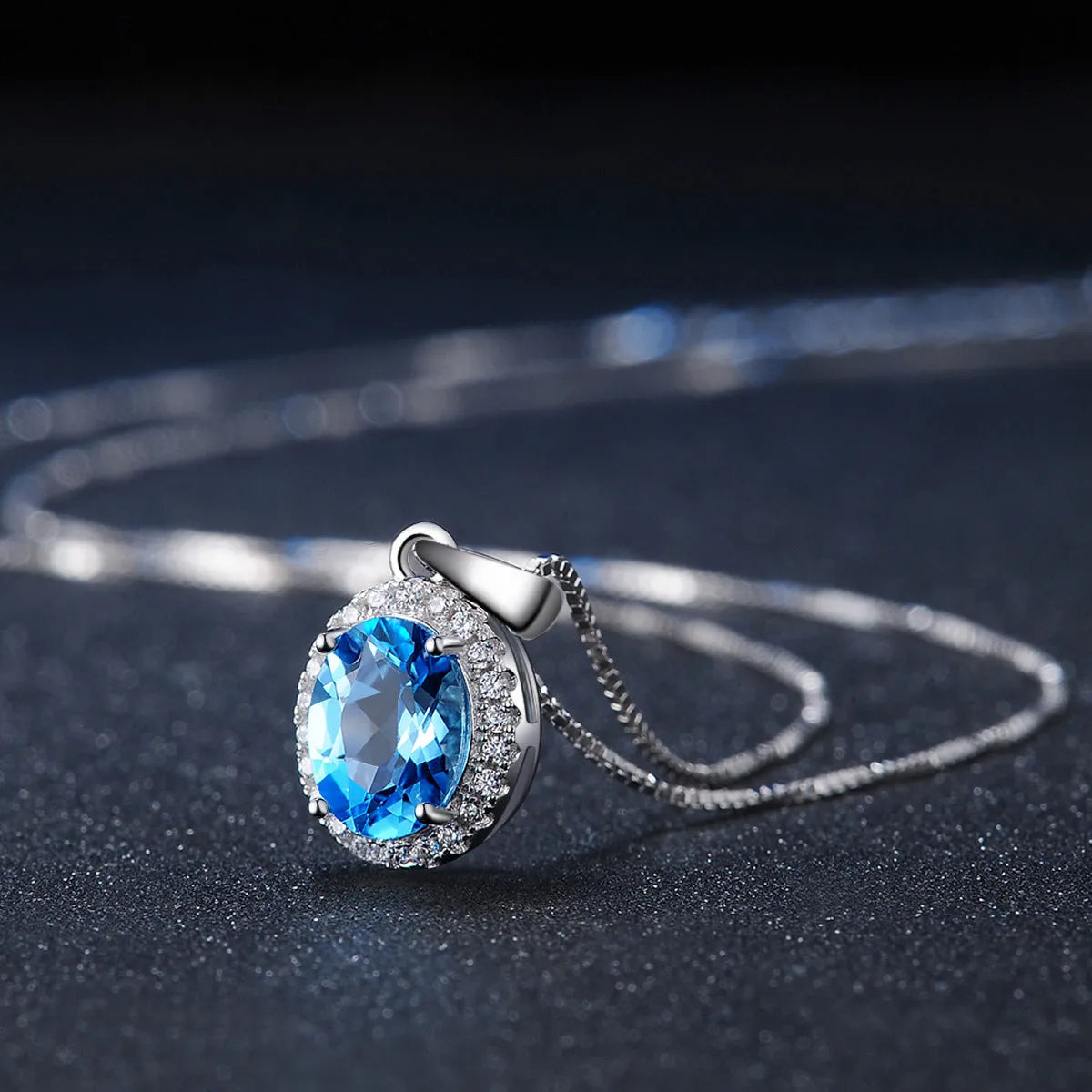 Four-piece 925 Sterling Silver geometric jewellery set with blue topaz gems, showing earrings, ring, pendant, and necklace.