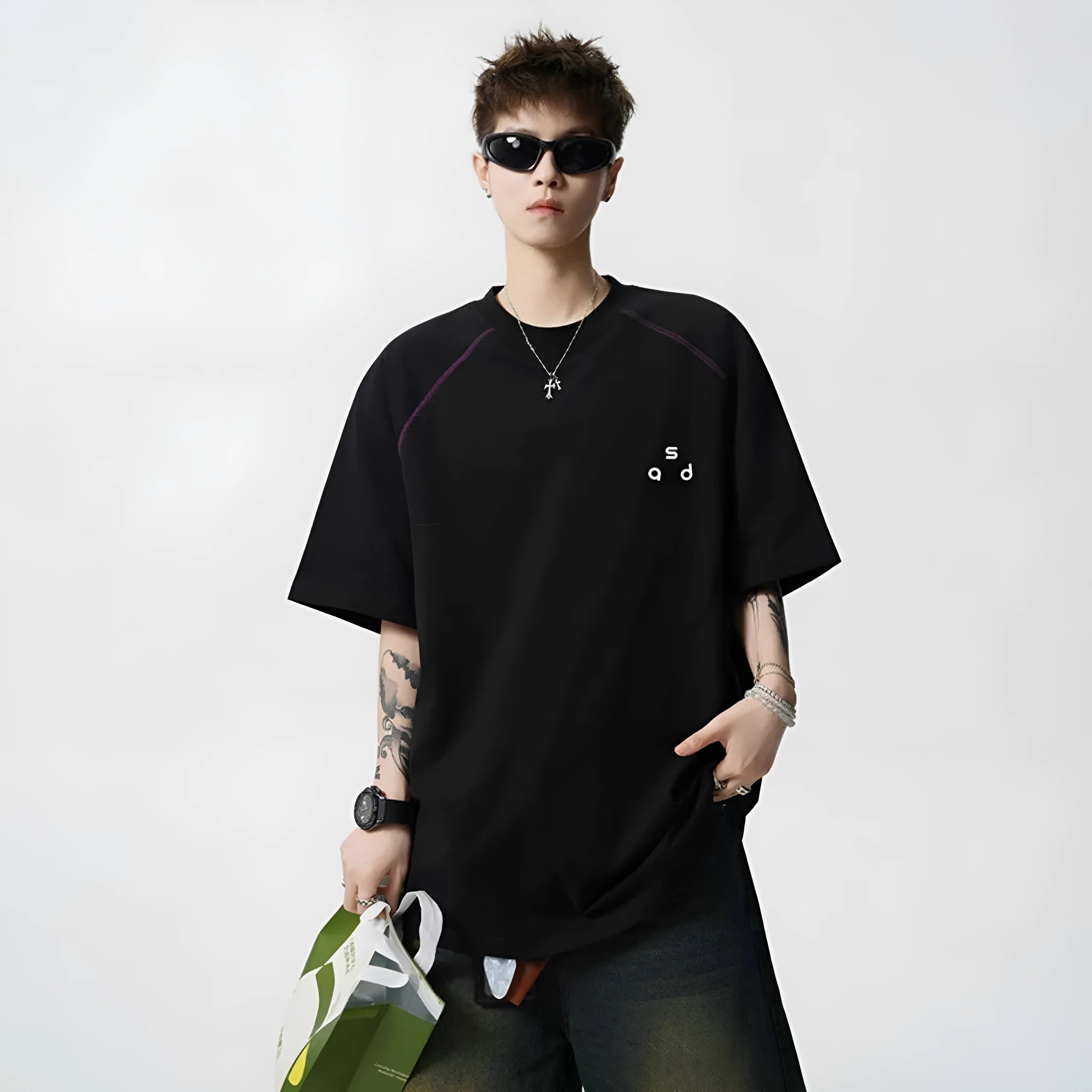 Man wearing a black loose-fit cotton T-shirt with a letter print on the chest.
