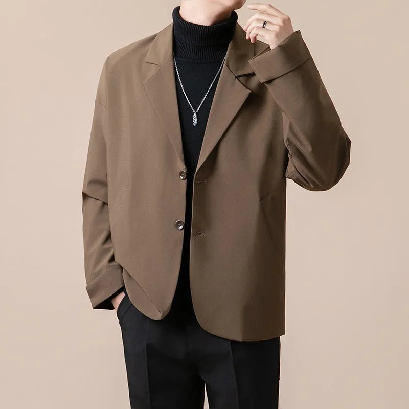 A man wearing a loose-fit casual suit jacket in a light colour, suitable for smart-casual occasions.