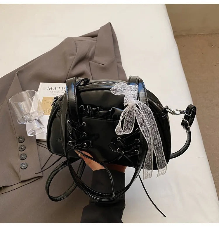Milky white women's PU shoulder bag with a black bandage bow and sewing thread detail.