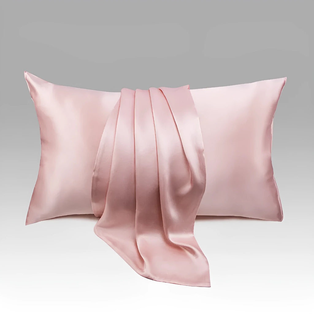 Dark grey mulberry silk pillowcase with an envelope closure on a bed.
