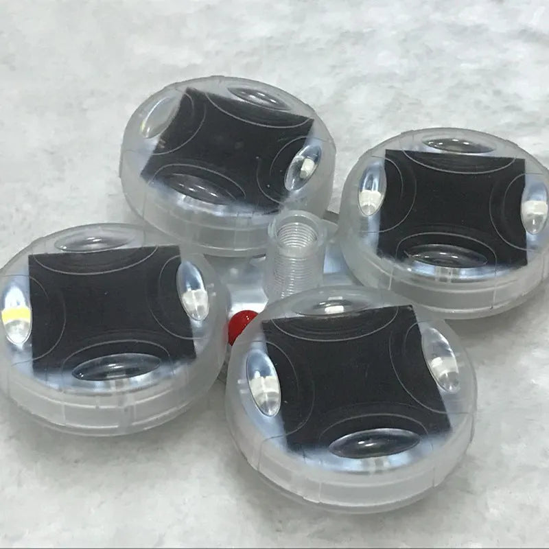 Colourful solar-powered LED valve flash lights mounted on a vehicle wheel hub.