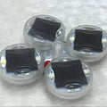 Colourful solar-powered LED valve flash lights mounted on a vehicle wheel hub.