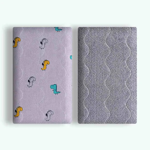 A soft cotton velvet pet blanket with a colourful dinosaur print, shown folded next to a dog bed.