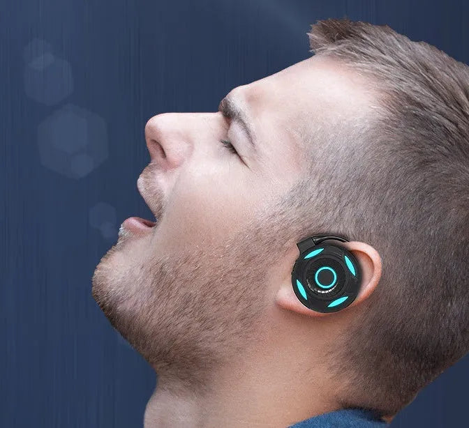 Black wireless Bluetooth gaming earphones with hanging ear design and USB charging cable