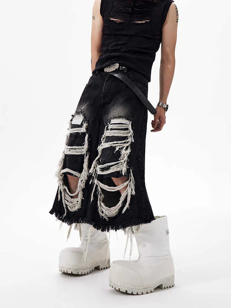 Black cropped wide-leg jeans with ripped patch detail on the leg, showing a mid-high waist and loose fit.