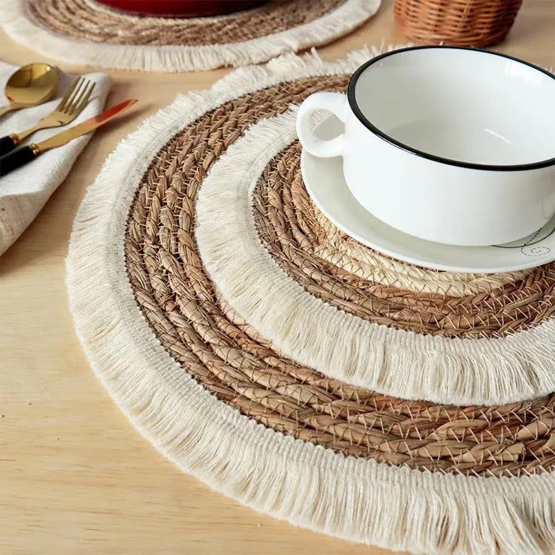 Round natural papyrus placemat with decorative tassels on a wooden table, shown in various sizes.