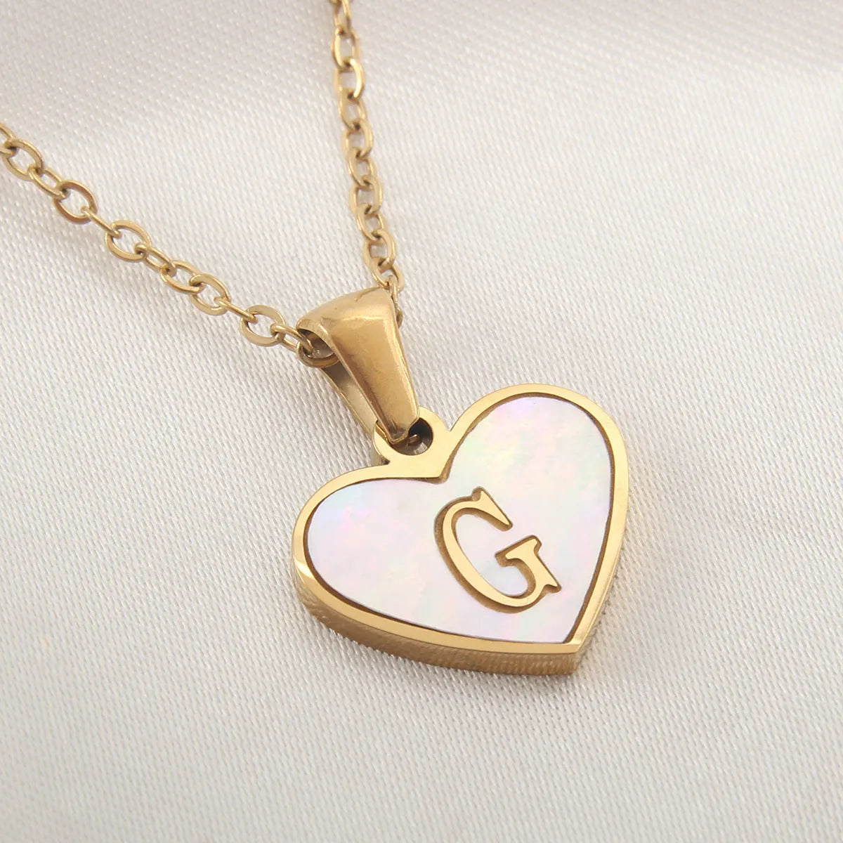 Gold plated heart-shaped personalised necklace with white shell charm on an adjustable chain.