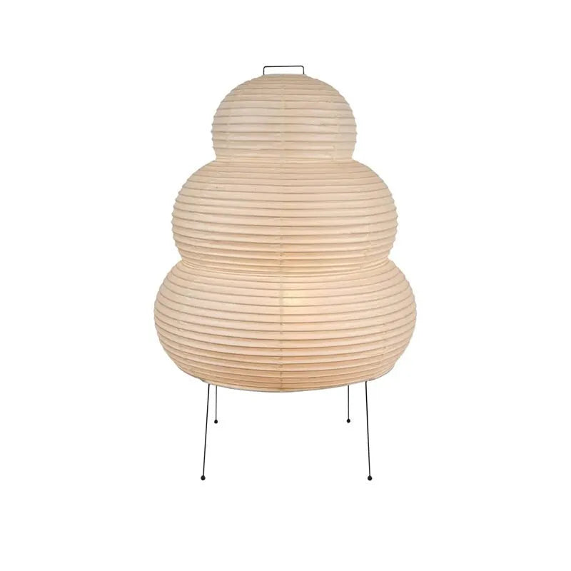 Japanese style handmade rice paper lantern table lamp with aluminium base on a wooden table.