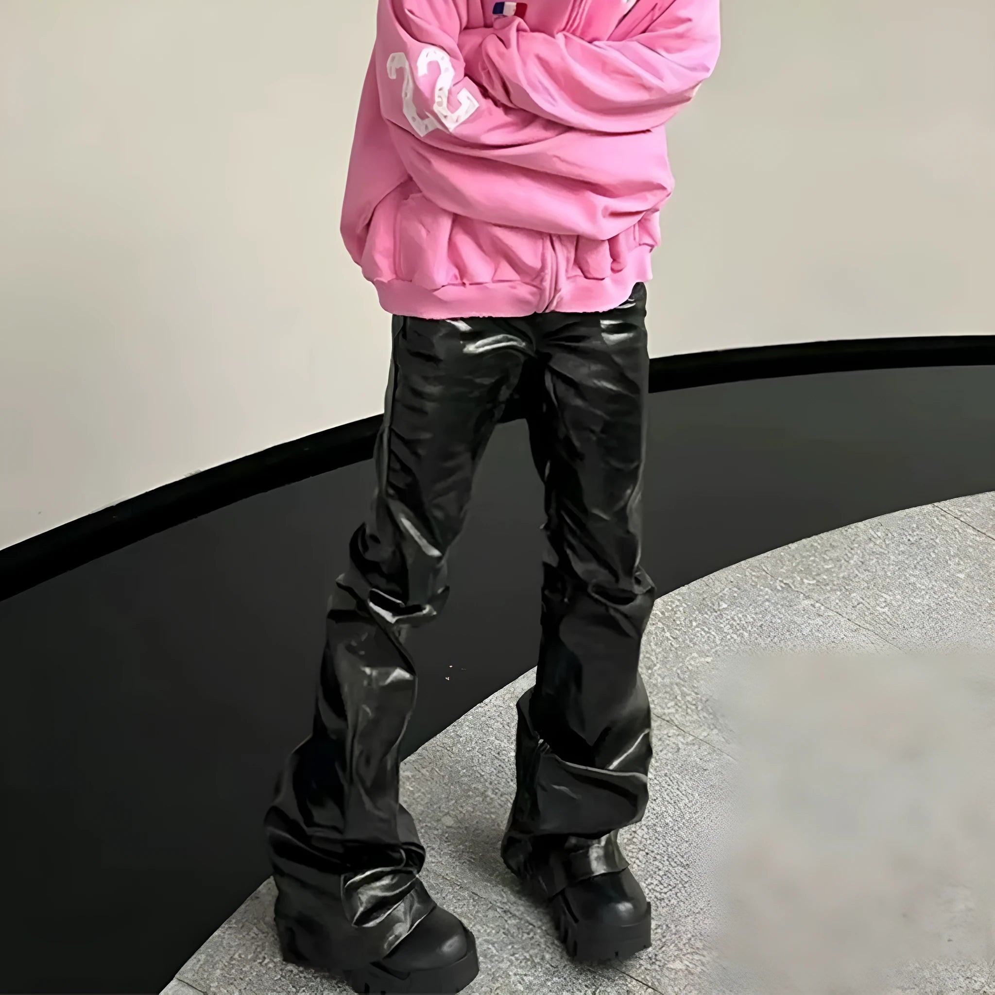 Black coated patent leather skinny jeans in a straight-leg cut on a model.