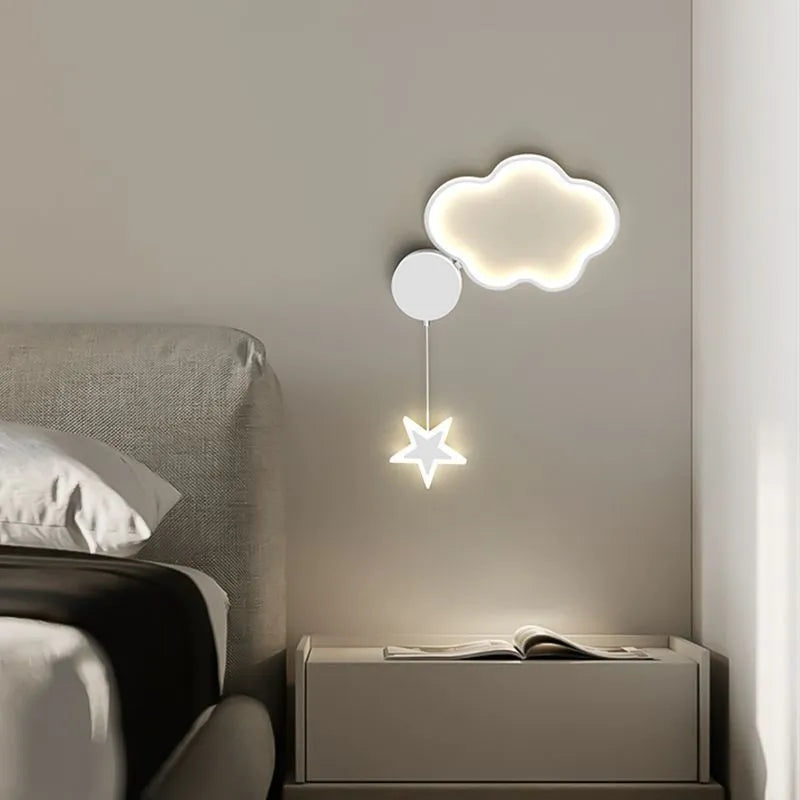 A white cloud-themed children's wall lamp with a left-facing orientation and LED light mounted on a bedroom wall.