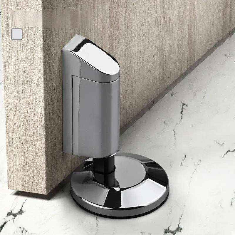 Modern zinc alloy invisible door stopper in brushed nickel finish on a wooden floor.
