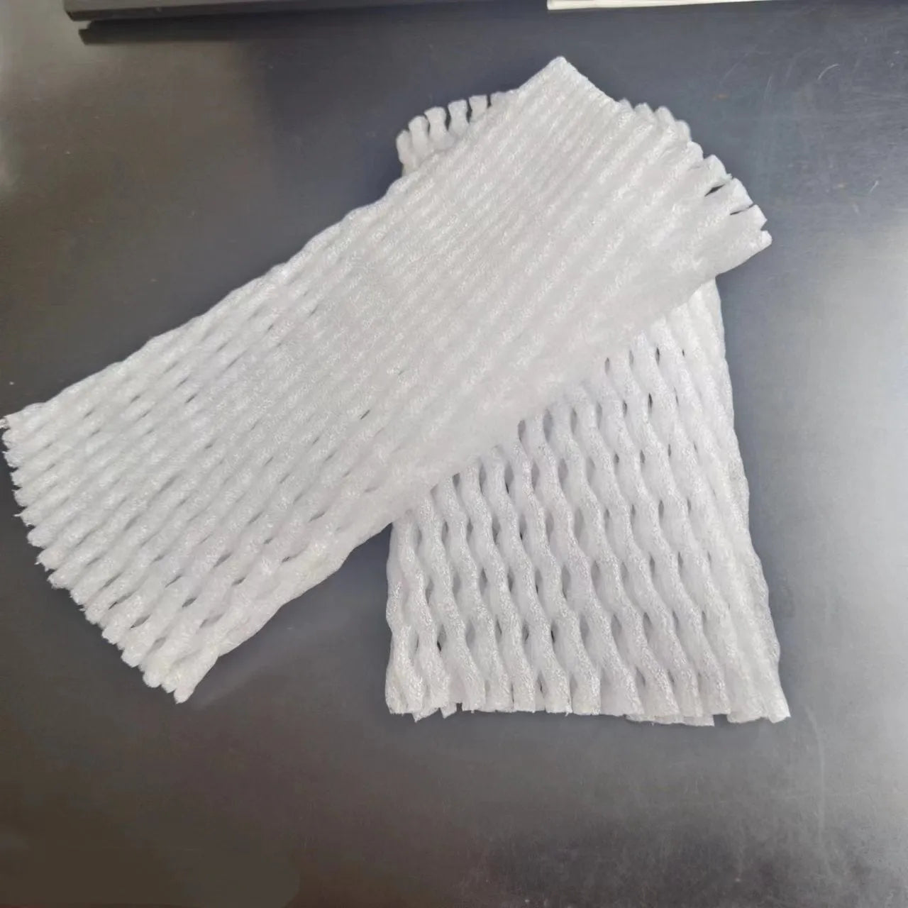 White foam and elastic net protective case for fruits, shown with size options for apples and pears.