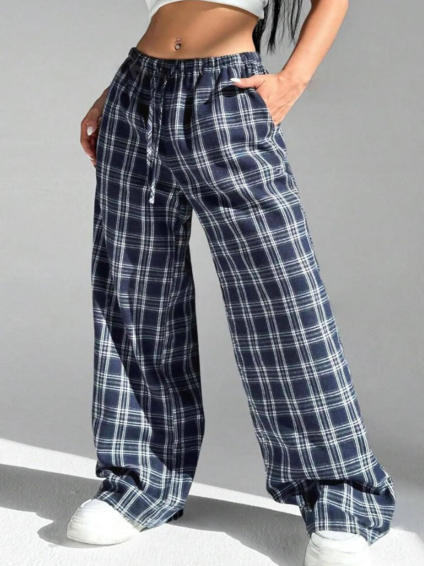 Red women's loose fit plaid trousers with drawstring waist and pockets on a mannequin.