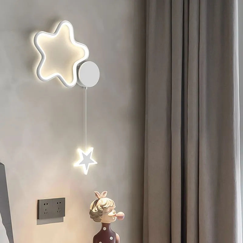 A white cloud-themed children's wall lamp with a left-facing orientation and LED light mounted on a bedroom wall.