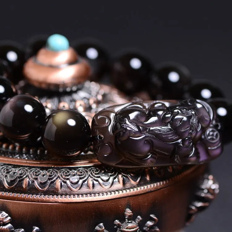 Natural crystal bracelet with a Pi Xiu charm and icy obsidian beads in geometric ethnic style.