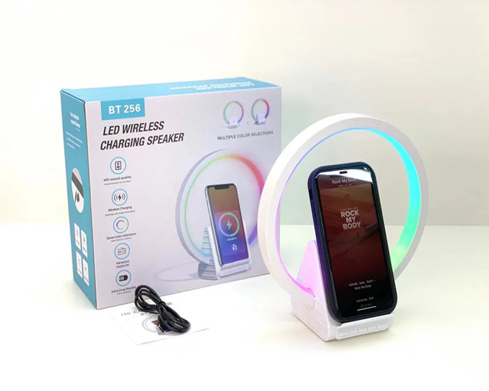 White square Bluetooth speaker with integrated wireless charging pad and ambient LED lighting.