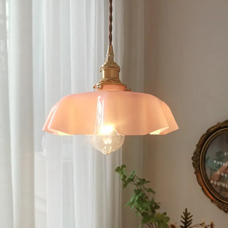 Medieval-style brass flower bud chandelier with a cream glass shade hanging from an adjustable cord.