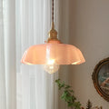 Medieval-style brass flower bud chandelier with a cream glass shade hanging from an adjustable cord.
