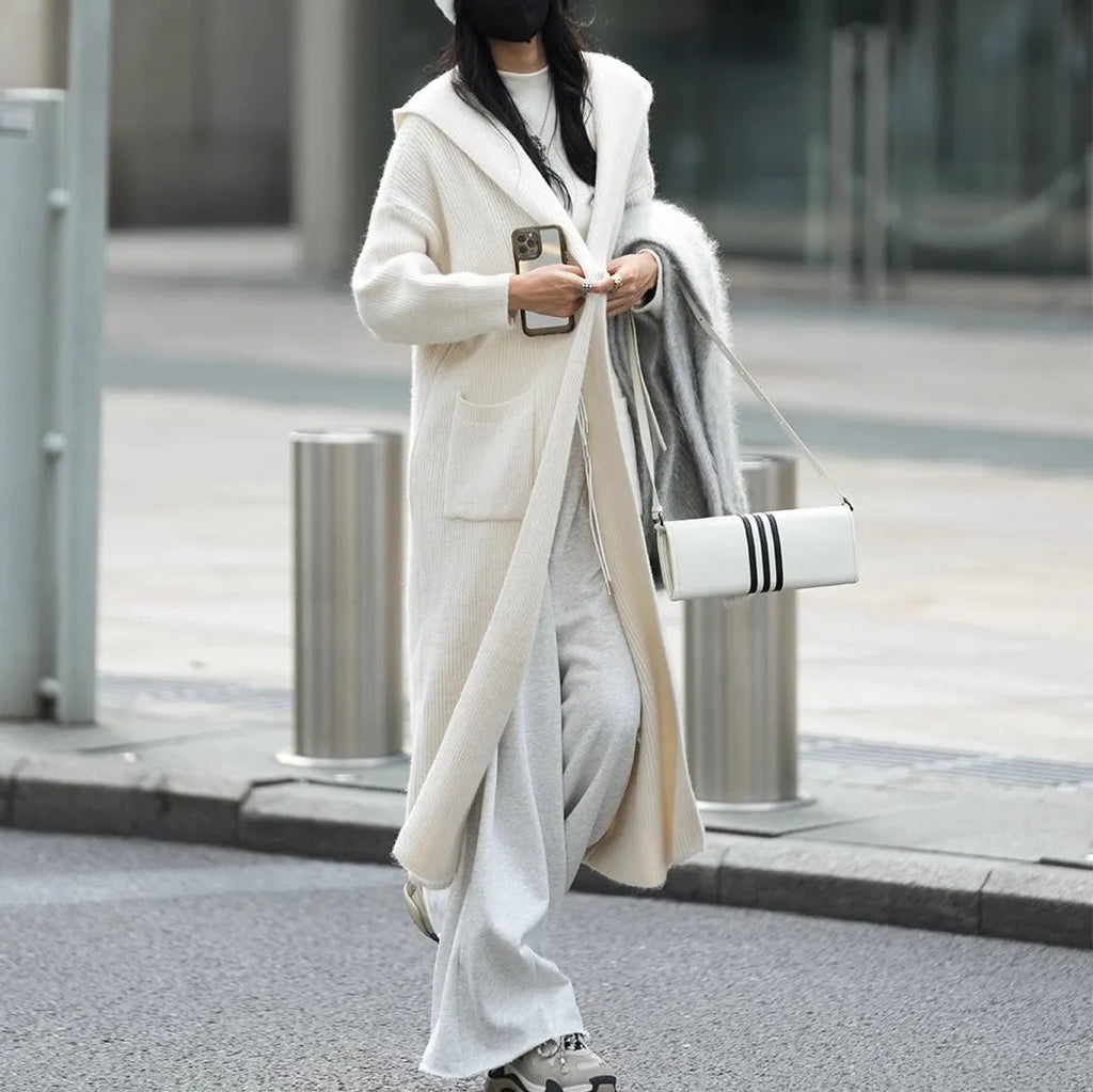 Long grey knitted hooded cardigan trench coat on a hanger showing its 80cm length and thick texture.