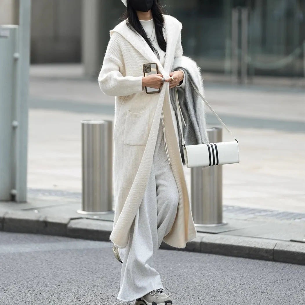 Long grey knitted hooded cardigan trench coat on a hanger showing its 80cm length and thick texture.