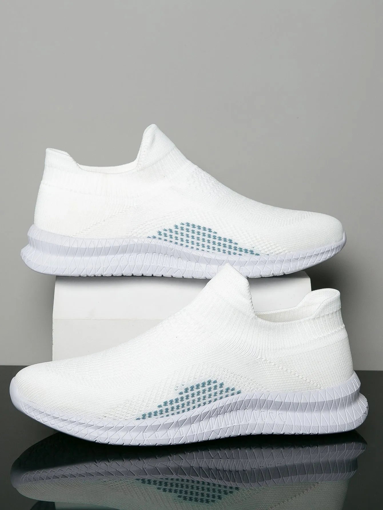 Popcorn Flyknit low top casual sneakers in white, black, and blue colours on a plain background.
