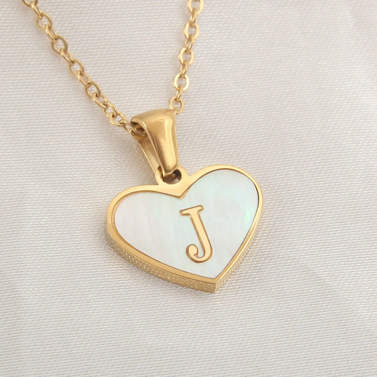 Gold plated heart-shaped personalised necklace with white shell charm on an adjustable chain.