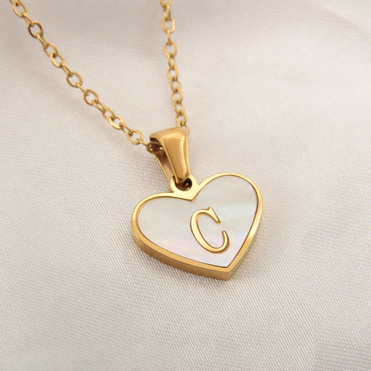Gold plated heart-shaped personalised necklace with white shell charm on an adjustable chain.