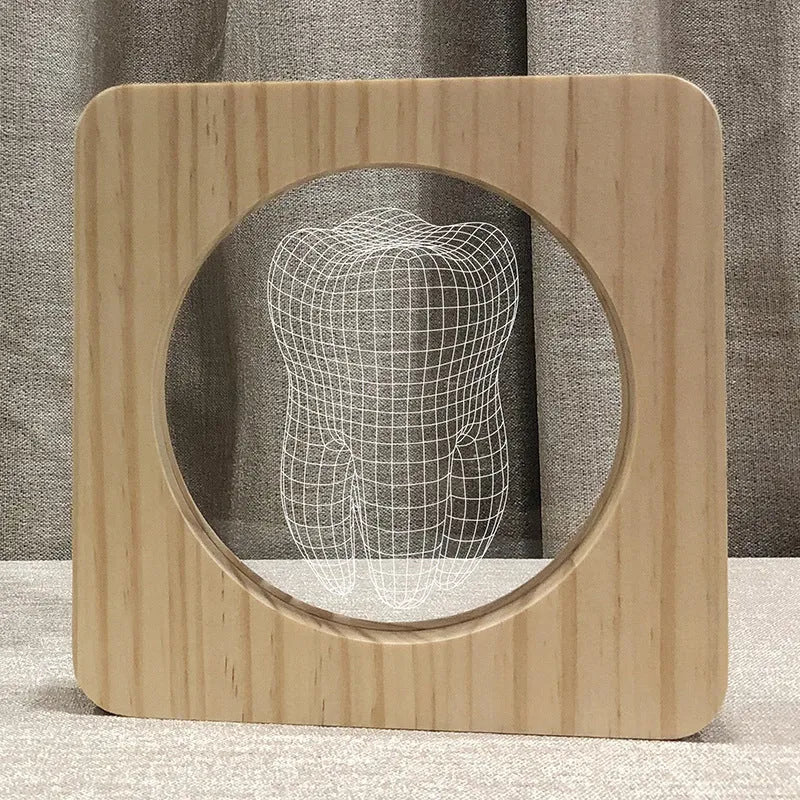 Wood-coloured tooth-shaped acrylic night lamp on a table with USB cable