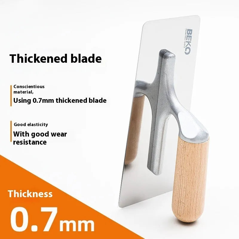 Three stainless steel putty scraper tools with wooden handles in different sizes on a workbench.