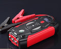Red car emergency jump starter power pack showing digital display and battery clips