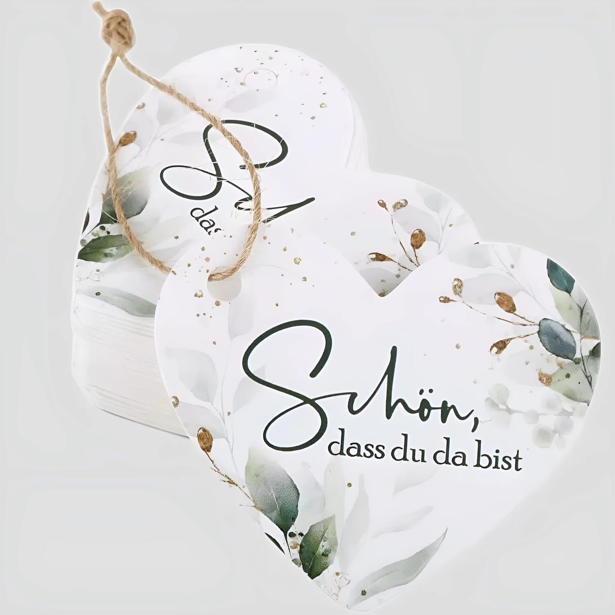 Set of 50 flower heart-shaped paper gift tags in two vintage designs on a table.