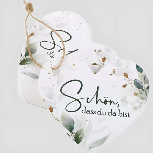 Set of 50 flower heart-shaped paper gift tags in two vintage designs on a table.