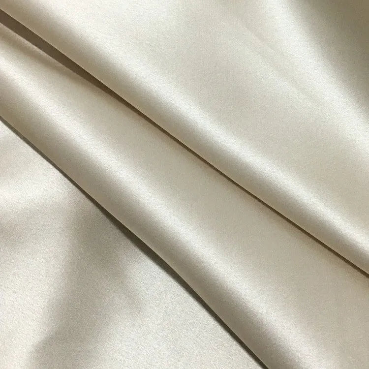 Dark grey mulberry silk pillowcase with an envelope closure on a bed.
