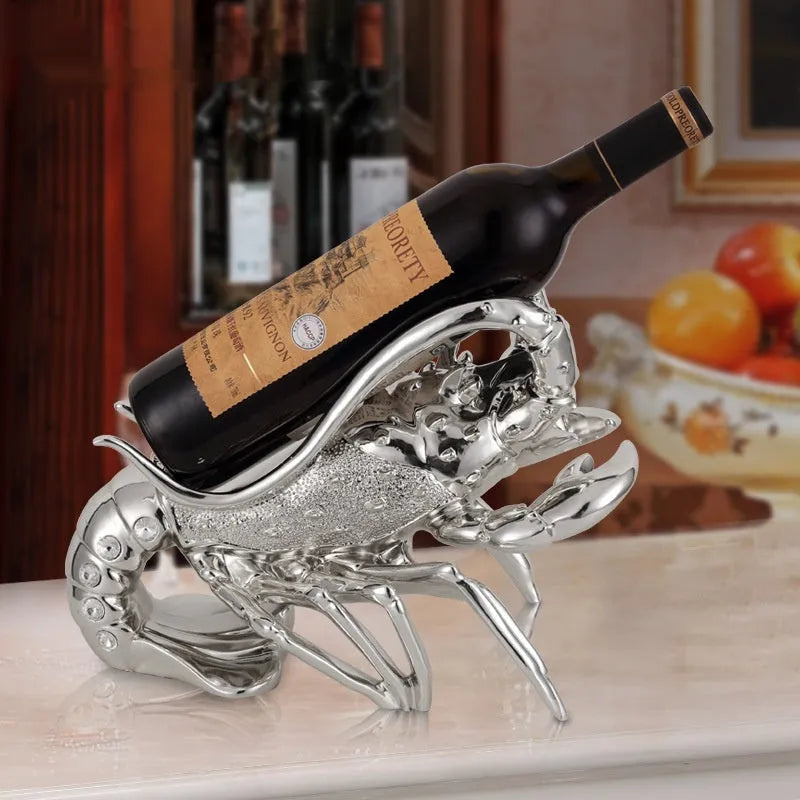 Rose gold resin lobster ornament holding a wine bottle on a wooden shelf.