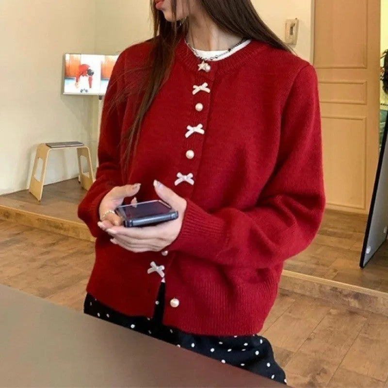 Women's solid colour cardigan sweater with pearl buttons in a light blue shade, shown open.