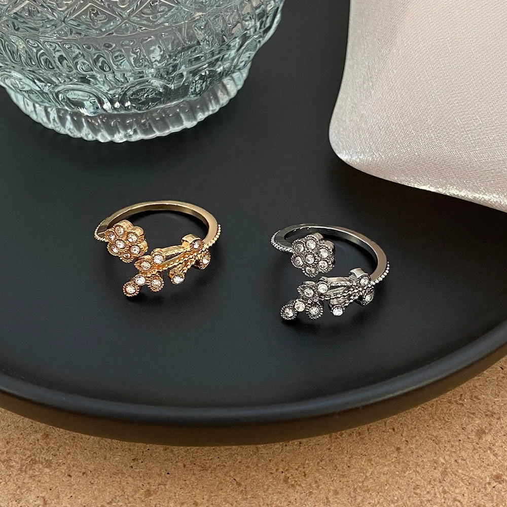 Gold and white copper open ring with diamond-finished flower and leaf design for women.