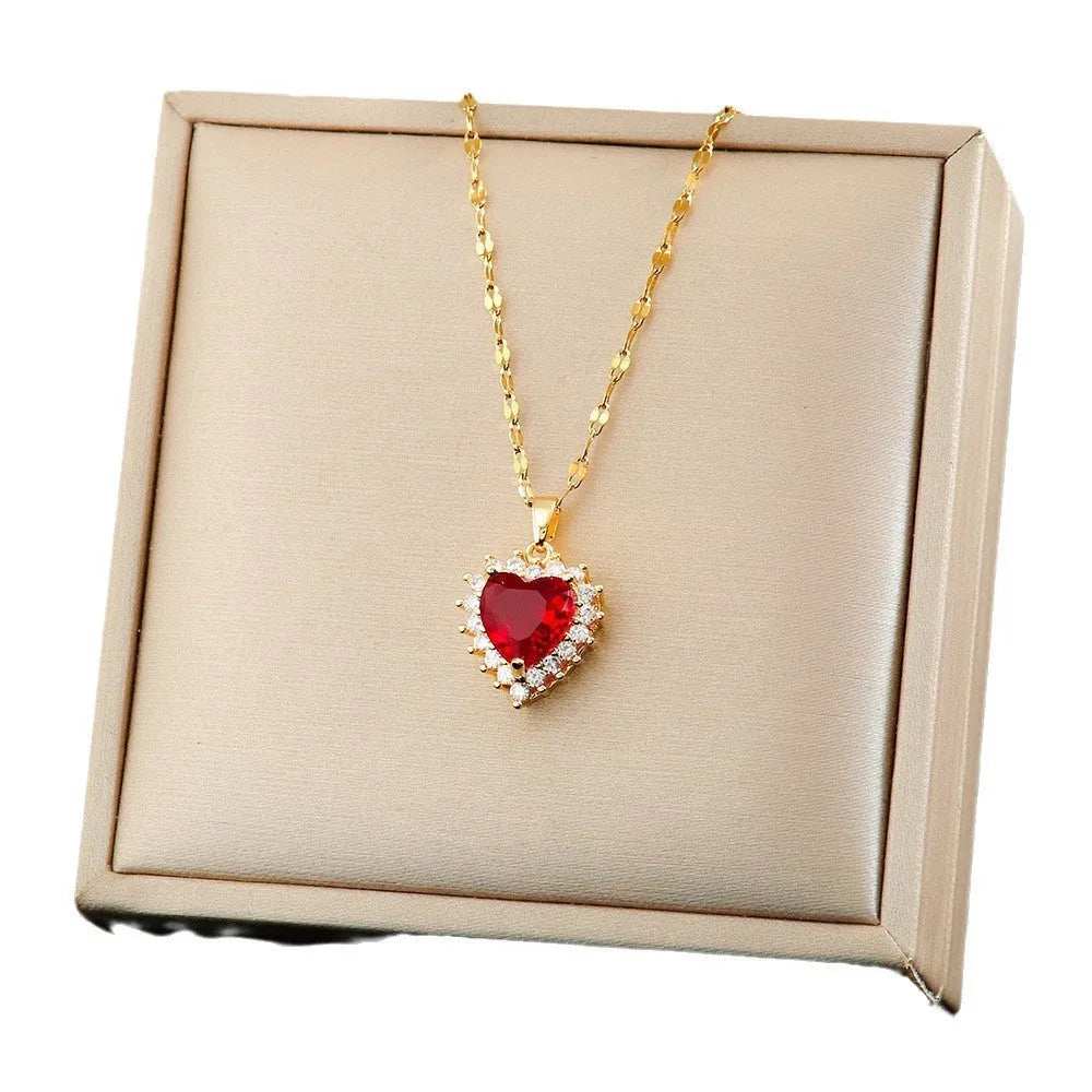 Gold red titanium steel jewellery set with heart flower pendant, matching earrings, and ring on a water wave chain.
