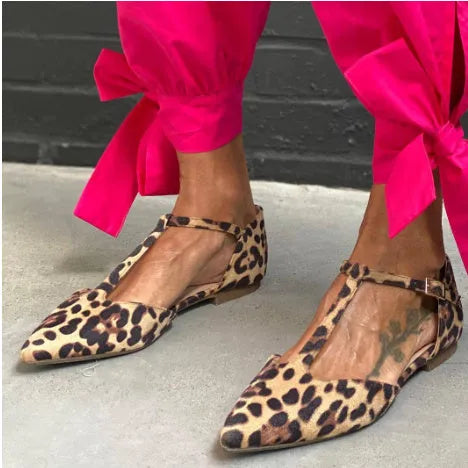 Leopard print women's pumps with a low chunky heel, pointed toe, and cross ankle straps.