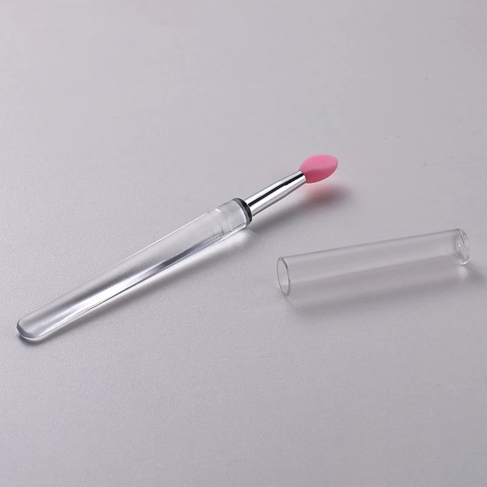 Set of coloured silicone lip brushes with protective caps for applying lipstick and lip gloss.