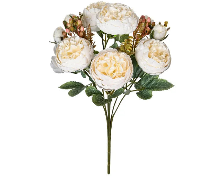 Silk artificial peony bouquet in champagne colour on a table.