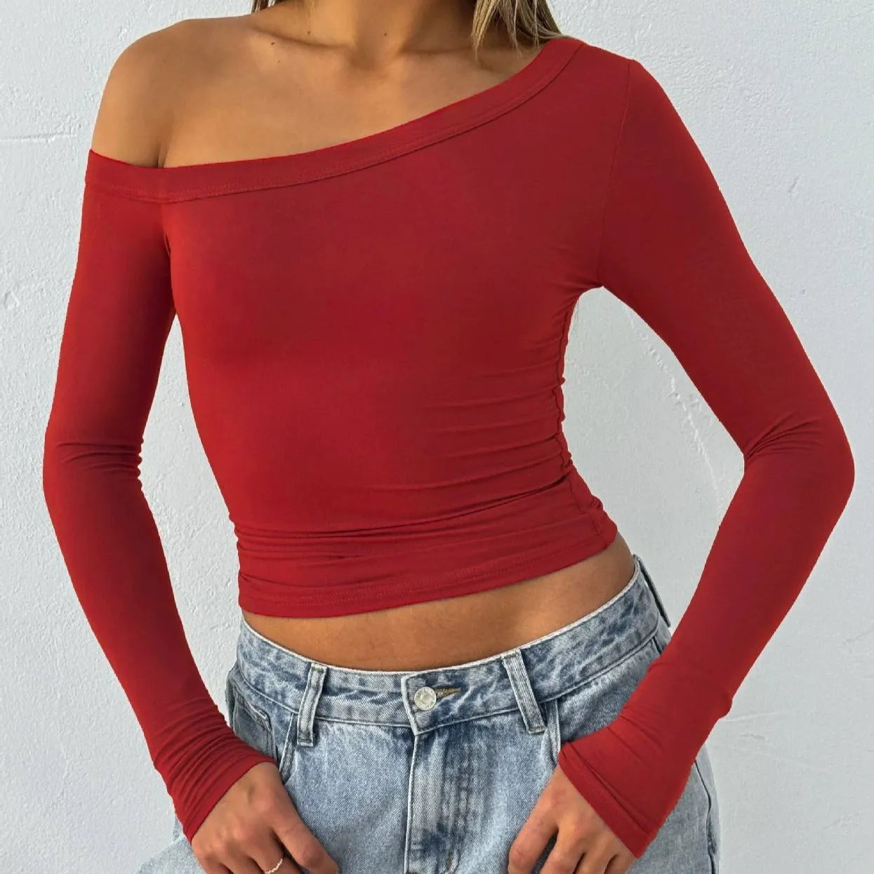 Women's solid colour knitted cardigan with cross shoulder straps and long sleeves.